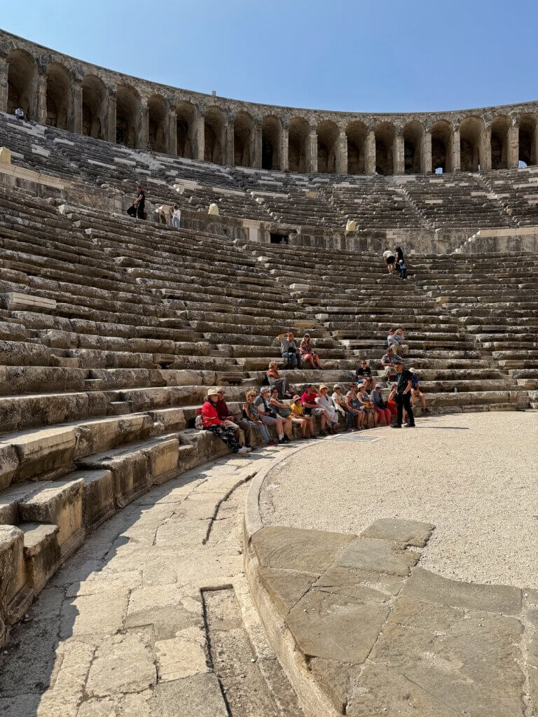 Besucher auf den unteren Sitzreihen des römischen Theaters von Aspendos