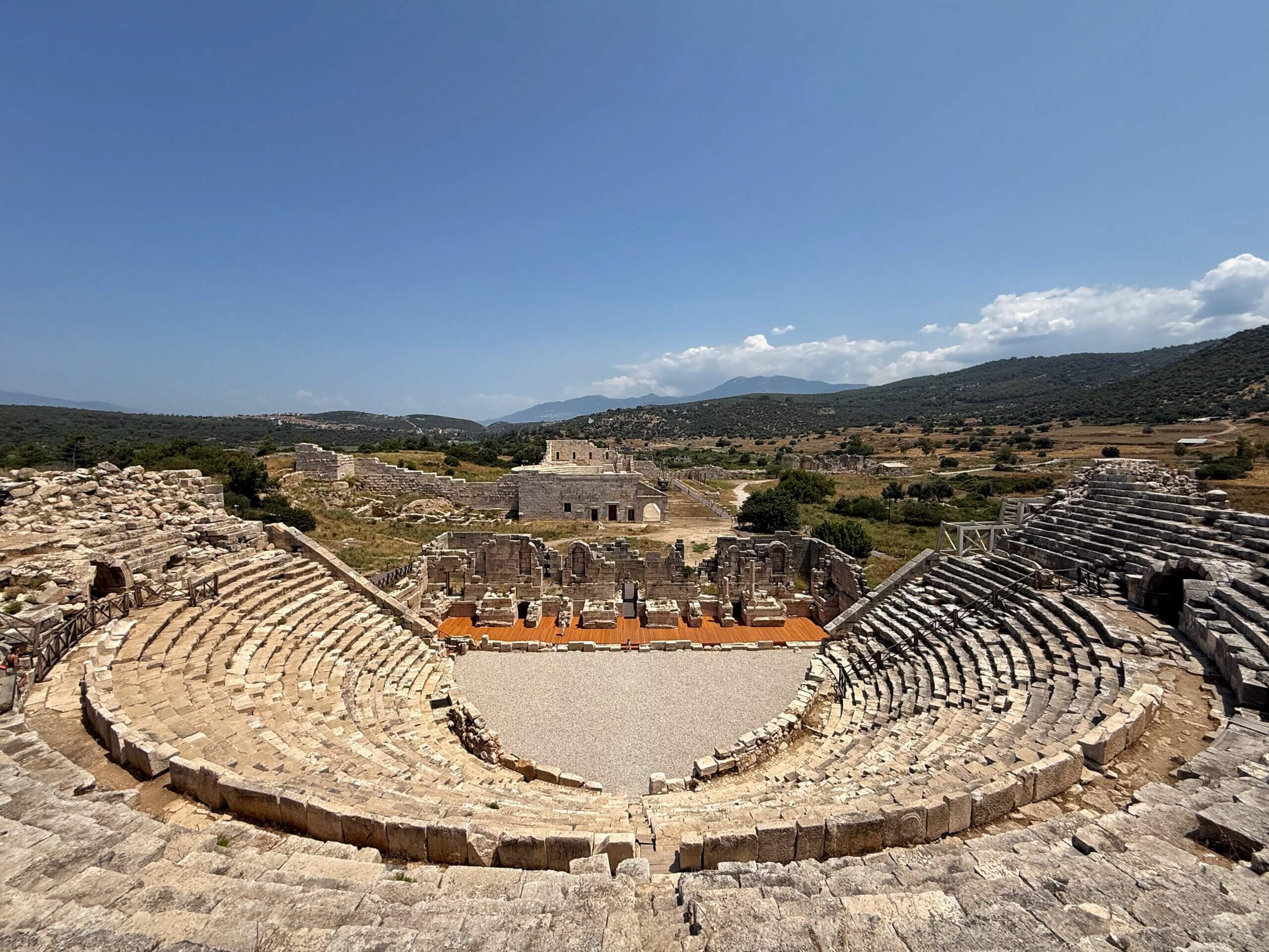 Gesamtansicht der halbkreisförmigen Zuschauerränge und der Bühne des antiken Theaters von Patara
