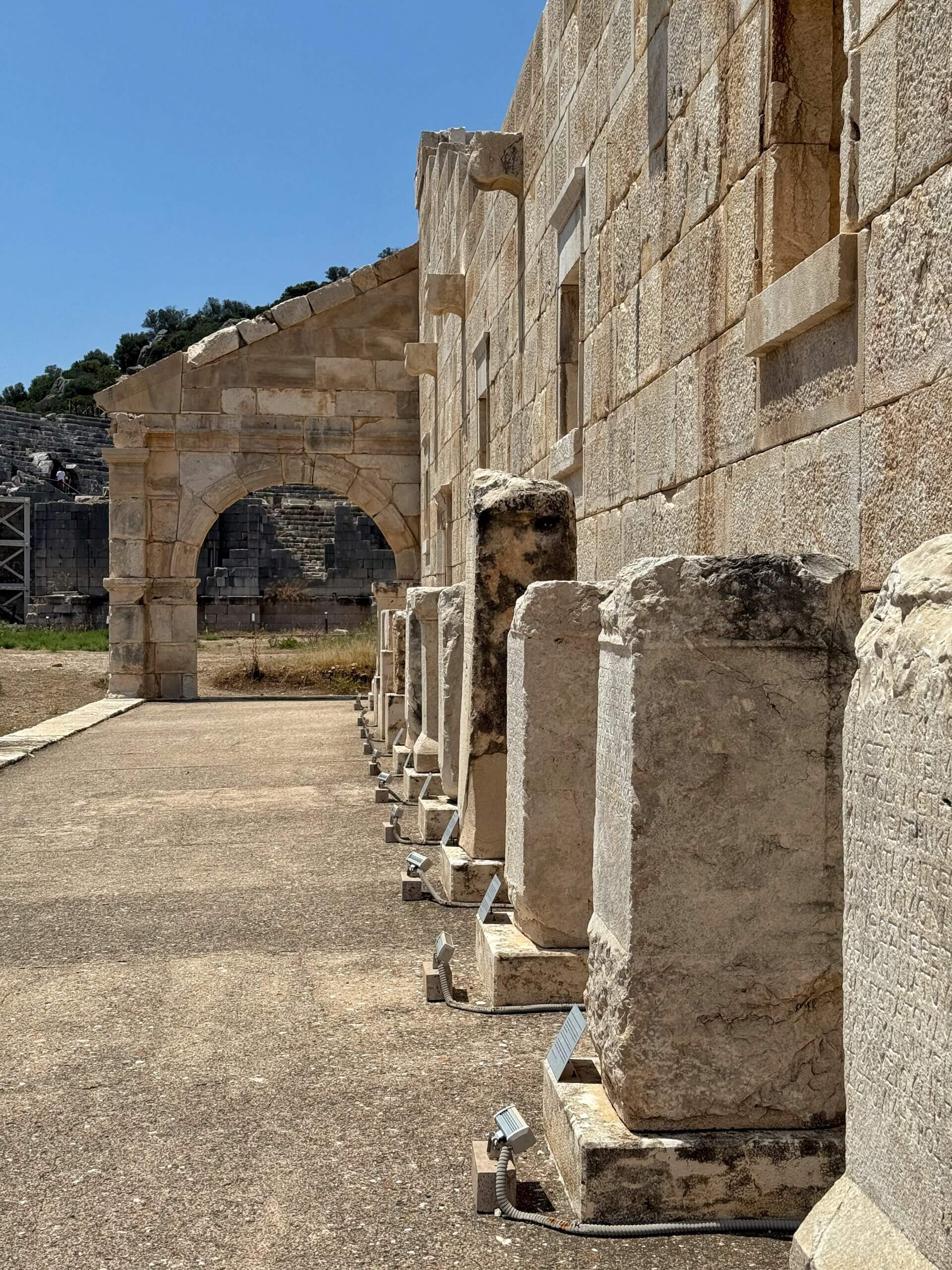 Antike Inschriftentafeln vor dem Bouleuterion von Patara mit dem Theater im Hintergrund